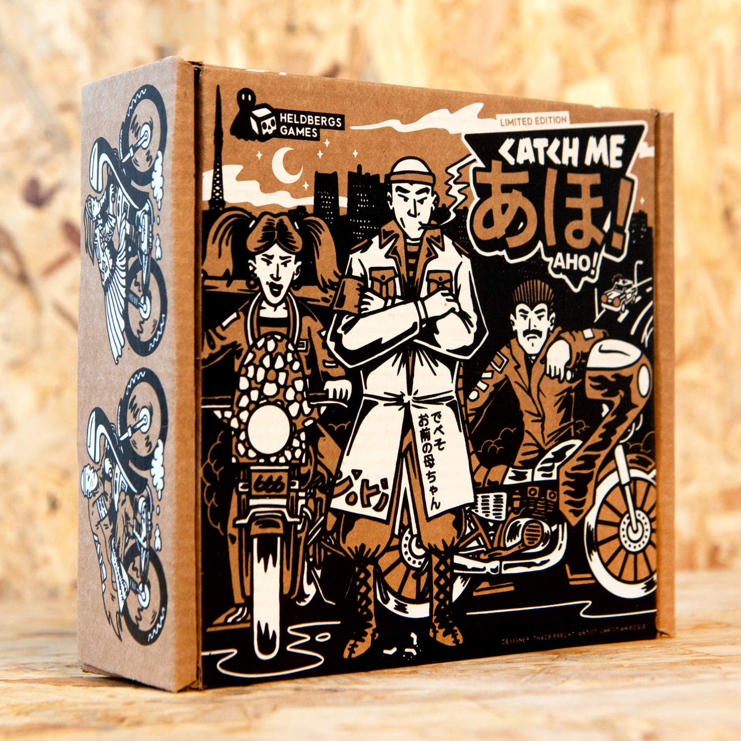 Die Verpackung des limitierten Strategiespiels „Catch Me Aho“ zeigt eine stilvolle Illustration von Bōsōzoku Speed Tribes und Sukeban in einer ikonischen 1980er-Jahre-Szene in Tokyo. Die Verpackung vereint einen Retro-Comic-Stil mit kräftigen Farben und Motiven der japanischen Straßenkultur, die das Thema des Spiels unterstreichen. Das Design transportiert die rebellische Atmosphäre, die das Spiel zu einem echten Sammlerstück macht.