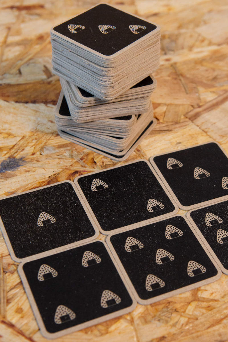 Detaillierte Ansicht der hochwertigen Spielkarten aus Kraftpapier, die das minimalistische, aber charakteristische Design des Spiels „Catch Me Aho“ unterstreichen. Die Karten sind robust und umweltfreundlich gestaltet und zeigen Symbole, die an die Ära der japanischen Bōsōzoku erinnern. Sie sind ein wichtiger Bestandteil des Spiels und spiegeln den Retro-Stil der 1980er-Jahre wider.