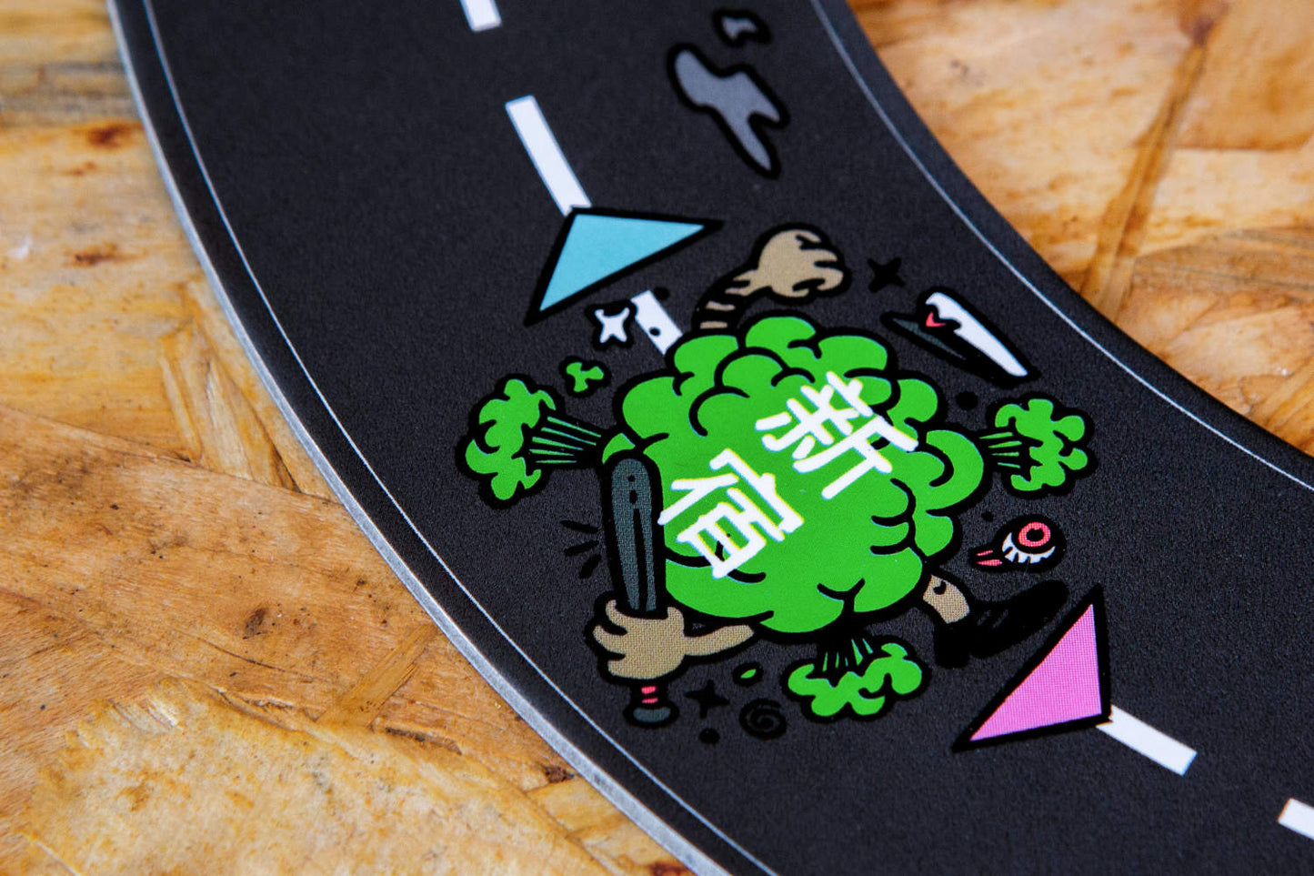 Detailansicht des sechsteiligen Rennstrecken-Puzzleplans von „Catch Me Aho“, verziert mit dynamischen Illustrationen, die die Spannung und das Adrenalin eines Straßenrennens vermitteln. Die stilisierten Symbole und Charaktere auf der Strecke spiegeln die ikonische Ästhetik der 1980er-Jahre-Bōsōzoku-Subkultur wider und unterstreichen den thematischen Schwerpunkt des Spiels auf Rebellion und Taktik.